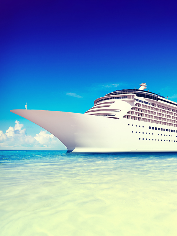 Photograph of the front of a cruise ship near the coast taken from ground level.