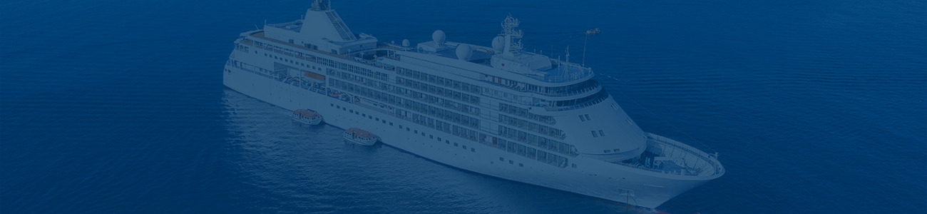 Photograph of a cruise ship with an island in the background, the image has a blue filter.