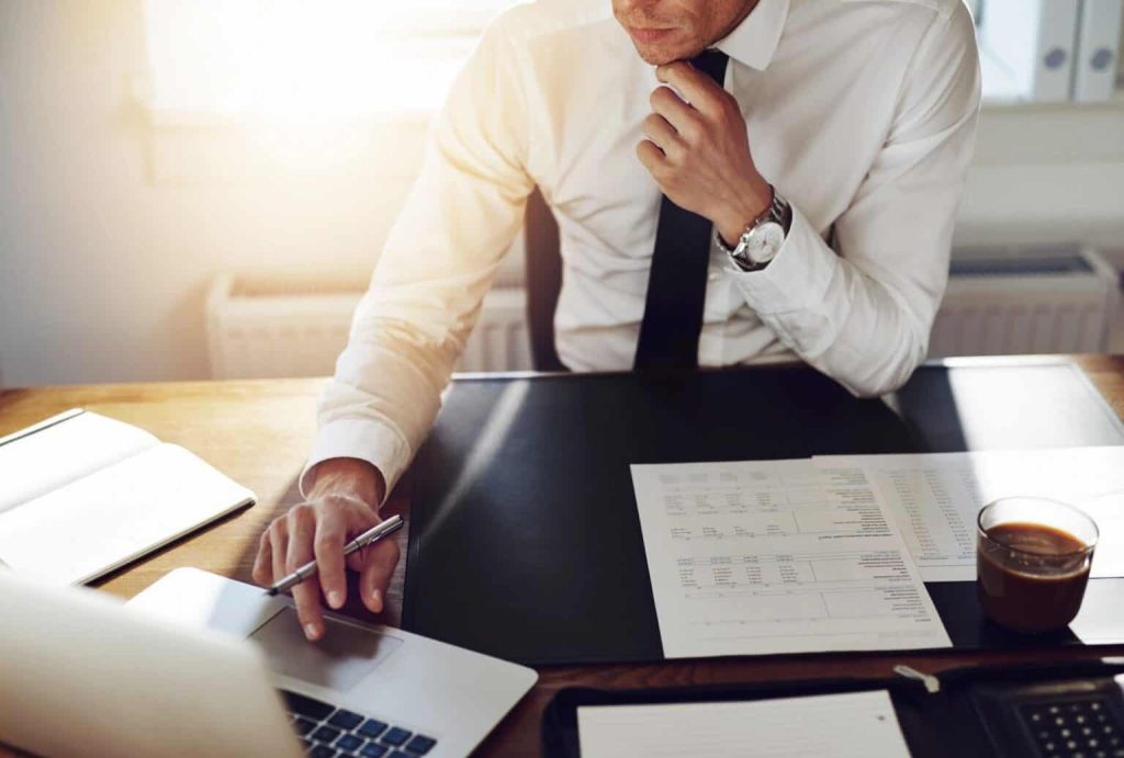 lawyer-sitting-at-desk-looking-at-contract